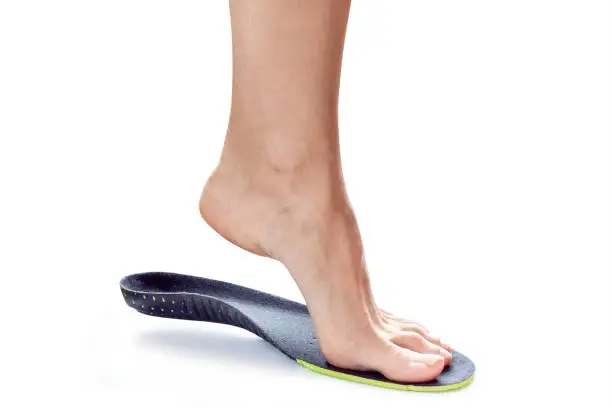 female foot stands on their toe in orthopedic insole