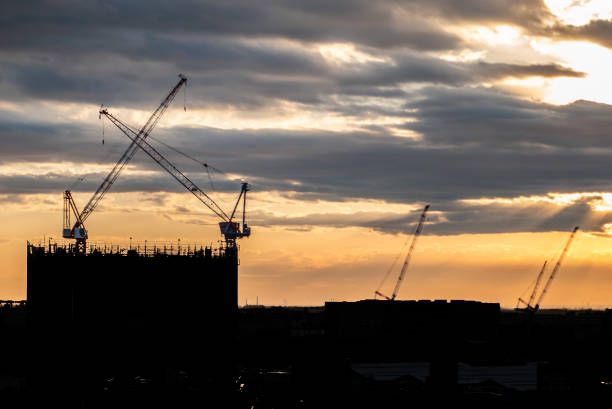 istock Silhouette Crane and building At Construction Site During Sunset. 1019324302