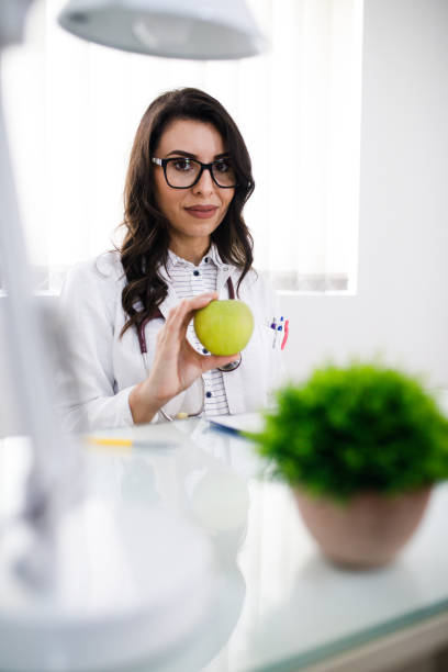 istock Nutritionist woman with green apple 1019329068