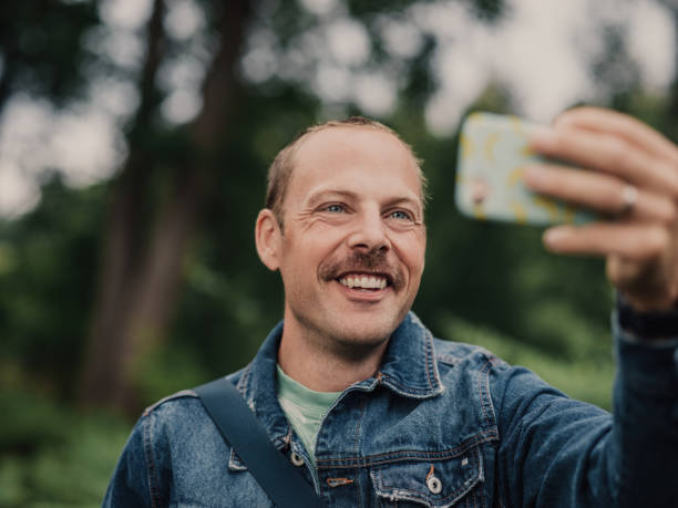 istock Man in mustasch and denim jacket outdoors in nature 1019329722