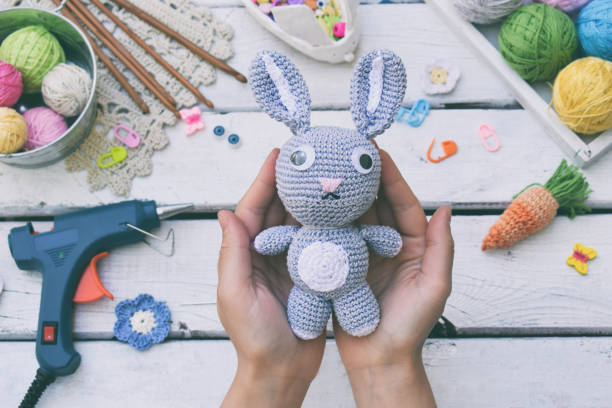istock Making rabbit with carrot. Crochet bunny for child. On table threads, needles, hook, cotton yarn. Handmade crafts. DIY concept. Small business. Income from hobby. 1019334568