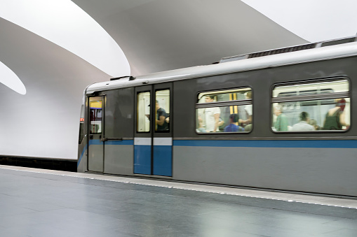 passenger modern subway train running fast on a station motion blur