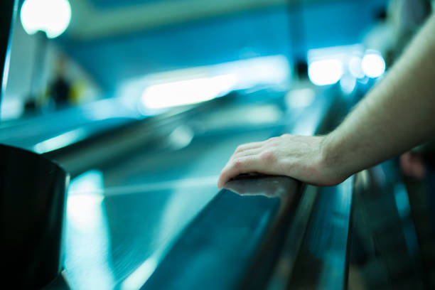 istock close up person's hand moving up on the escalator in subway 1019335630
