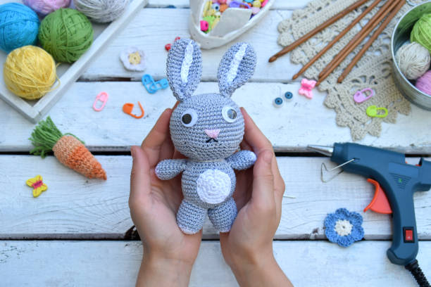 istock Making rabbit with carrot. Crochet bunny for child. On table threads, needles, hook, cotton yarn. Handmade crafts. DIY concept. Small business. Income from hobby. 1019339168
