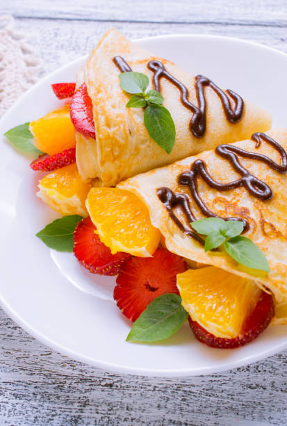istock Pancakes with chocolate, sliced strawberries and orange 1019345270