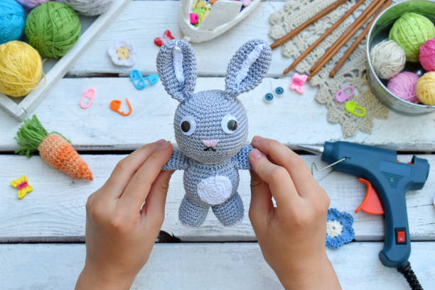 istock Making rabbit with carrot. Crochet bunny for child. On table threads, needles, hook, cotton yarn. Handmade crafts. DIY concept. Small business. Income from hobby. 1019345324