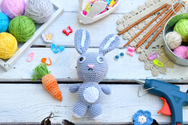 istock Making rabbit with carrot. Crochet bunny for child. On table threads, needles, hook, cotton yarn. Handmade crafts. DIY concept. Small business. Income from hobby. 1019345436