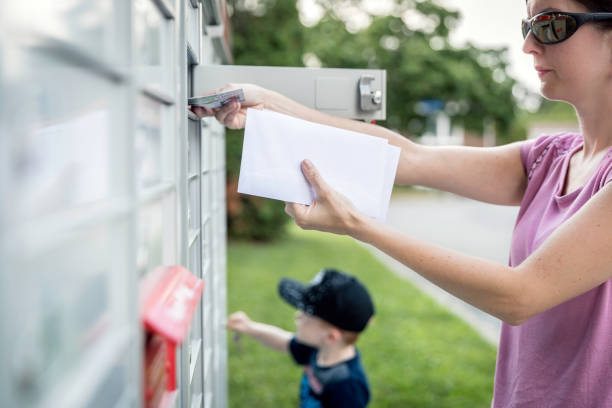 istock Woman hand Picking up the Mail at Postal Mailbox with Young Boy 1019355528
