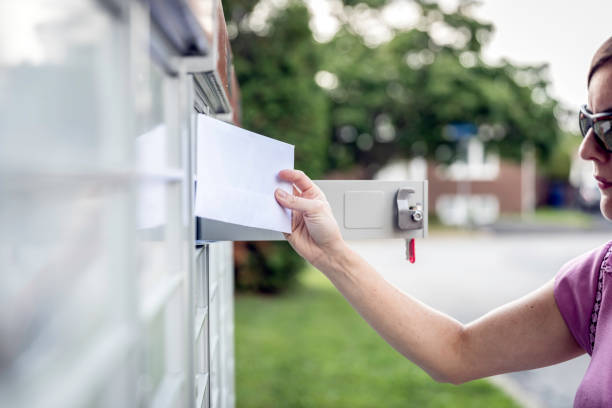 istock Woman hand Picking up the Mail at Postal Mailbox 1019355532