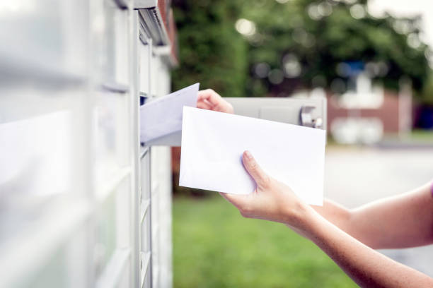 woman hand picking up the mail at postal mailbox - mailbox mail box open imagens e fotografias de stock