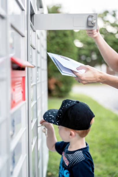 istock Woman hand Picking up the Mail at Postal Mailbox with Young Boy 1019355574