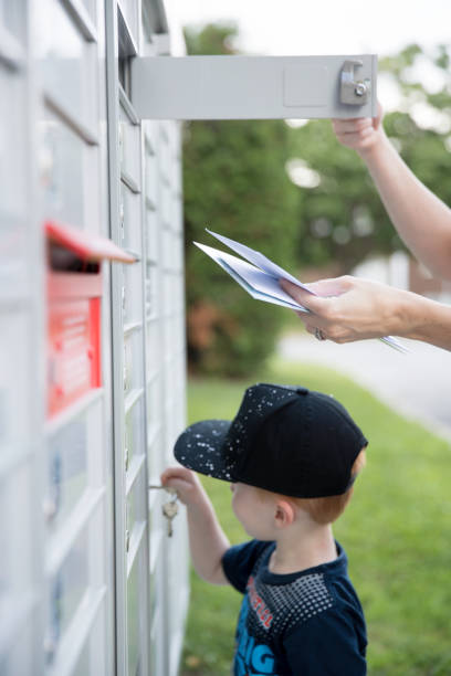 istock Woman hand Picking up the Mail at Postal Mailbox with Young Boy 1019355608