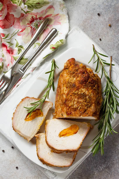 istock Meat roll (roulade) with with apricot stuffing and spices on a light stone or slate background. Thanksgiving day appetizer. Top view flat lay background, copy space. 1019368128