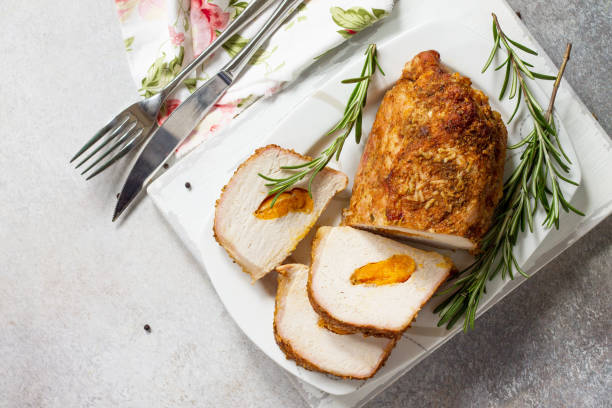istock Meat roll (roulade) with with apricot stuffing and spices on a light stone or slate background. Thanksgiving day appetizer. Top view flat lay background, copy space. 1019368132