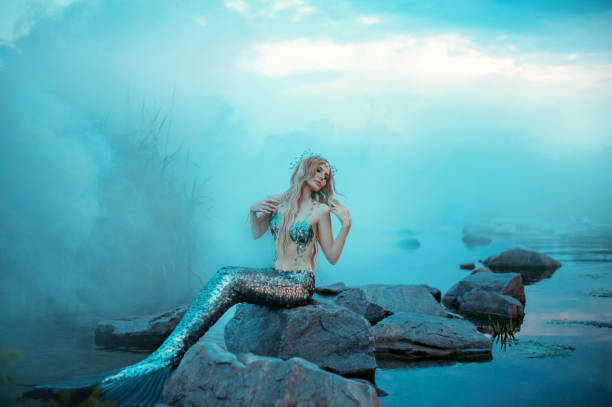 istock wonderful young mermaid is relaxing, warming herself in the evening sun 1019371804