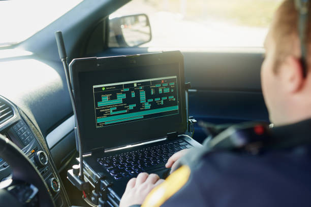 Logging in to the police database Cropped shot of an unrecognizable male police officer using his laptop while out on patrol database photos stock pictures, royalty-free photos & images