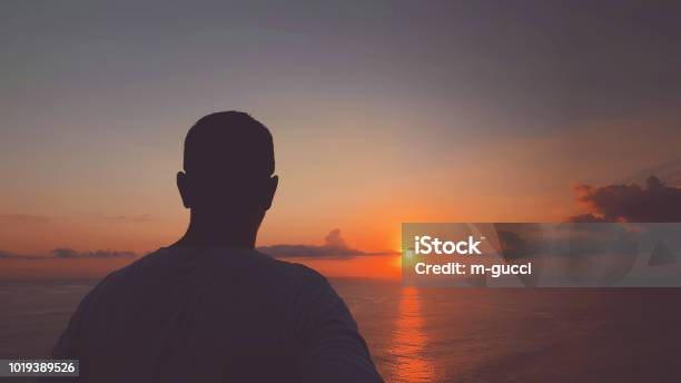 Silhouette Of Man In Sunset Sunrise Time Over The Ocean Stock Photo - Download Image Now