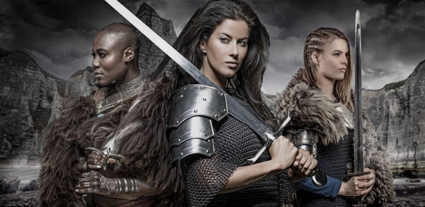 Three strong viking women Three Beautiful warrior viking princesses holding swords in front of a mountain range live action role playing photos stock pictures, royalty-free photos & images