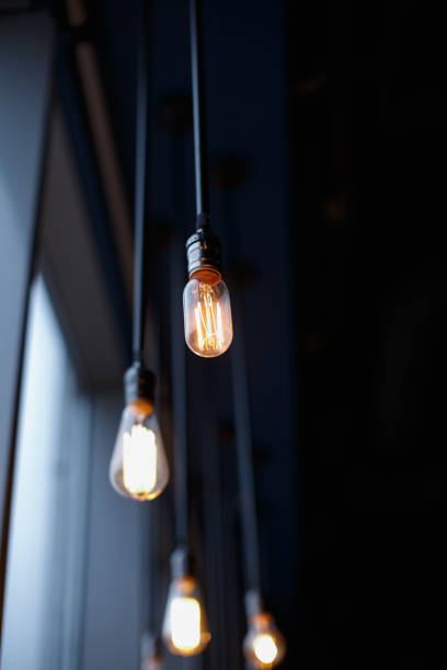 istock Retro light bulbs with weak glow hanging on wires to the ceiling. 1019399484