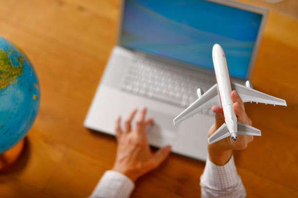istock Booking a flight with aircraft scale model at home. 1019400420
