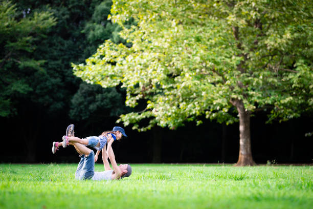 père et fille jouant dans le parc - short phrase photos et images de collection