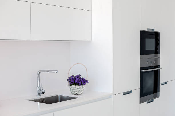 istock White kitchen interior. Minimalistic interior design. Modern furniture and built-in appliances. 1019403522