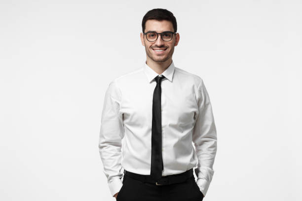 retrato de meio comprimento de jovens europeus caucasianos homem retratado isolado no fundo cinza, vestido de camisa branca e gravata e usando óculos, mostrando o sorriso positivo e disponibilidade para desenvolver - half smile - fotografias e filmes do acervo
