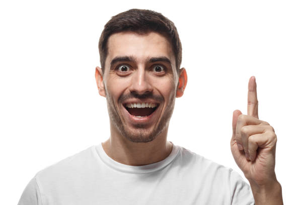 istock I have a great idea! Handsome man keeping finger pointed upwards, showing something above his head, making gesture with index finger, isolated on white background. Eureka, solution sign concept 1019406538