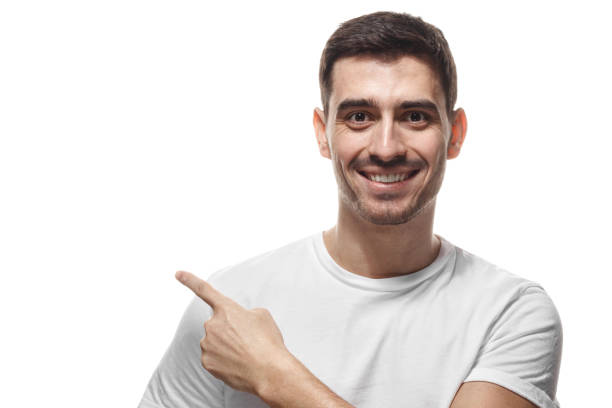 istock Handsome man in white t-shirt pointing left with finger isolated 1019406592