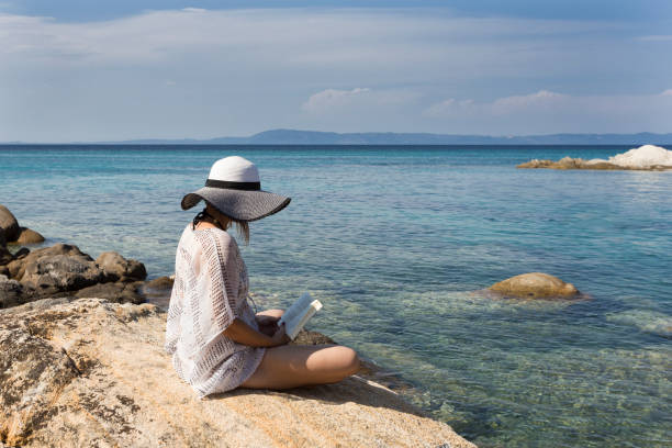 istock Girl reading a book on the beach. 1019412994