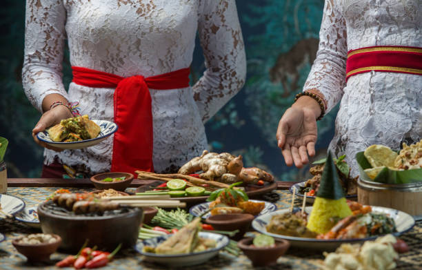 cocina indonesia - muchos platos balineses tradicionales sobre la mesa. camarera es comida - balinese culture fotografías e imágenes de stock