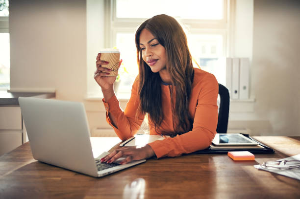 istock Smiling young entrepreneur working in her home office drinking coffee 1019423982