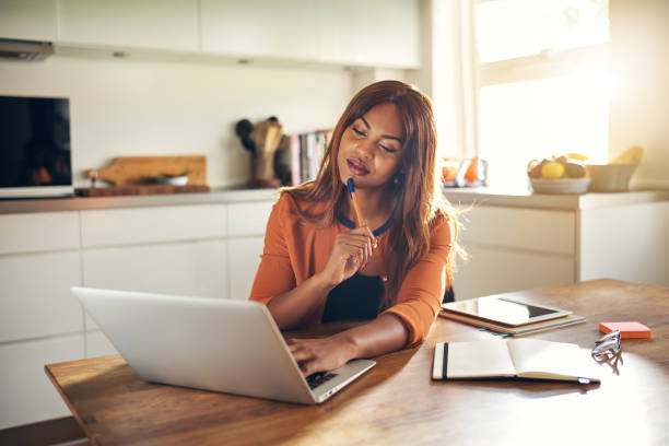 istock Young female entrepreneur thinking while working online in her kitchen 1019424022