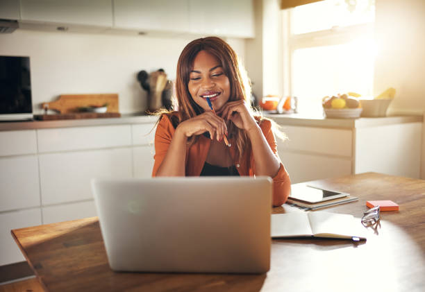 istock Young entrepreneur working online at her kitchen table at home 1019424044