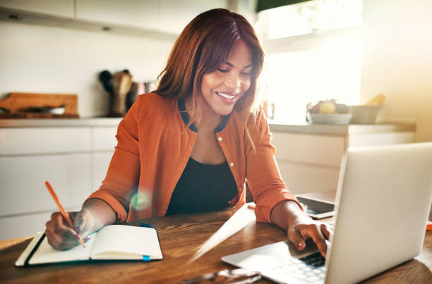 istock Smiling young female entrepreneur working at her kitchen table 1019424054