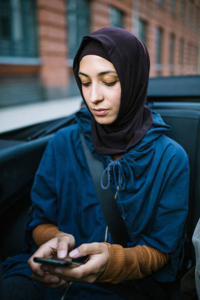 istock Young woman checking her phone in a car. 1019427108