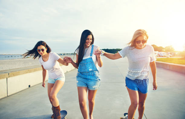istock Three young cheerful girls skateboarding in sunlight 1019427256