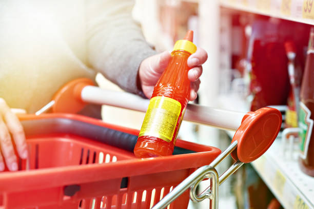 istock Hot chilli sauce in hand at grocery store 1019427444