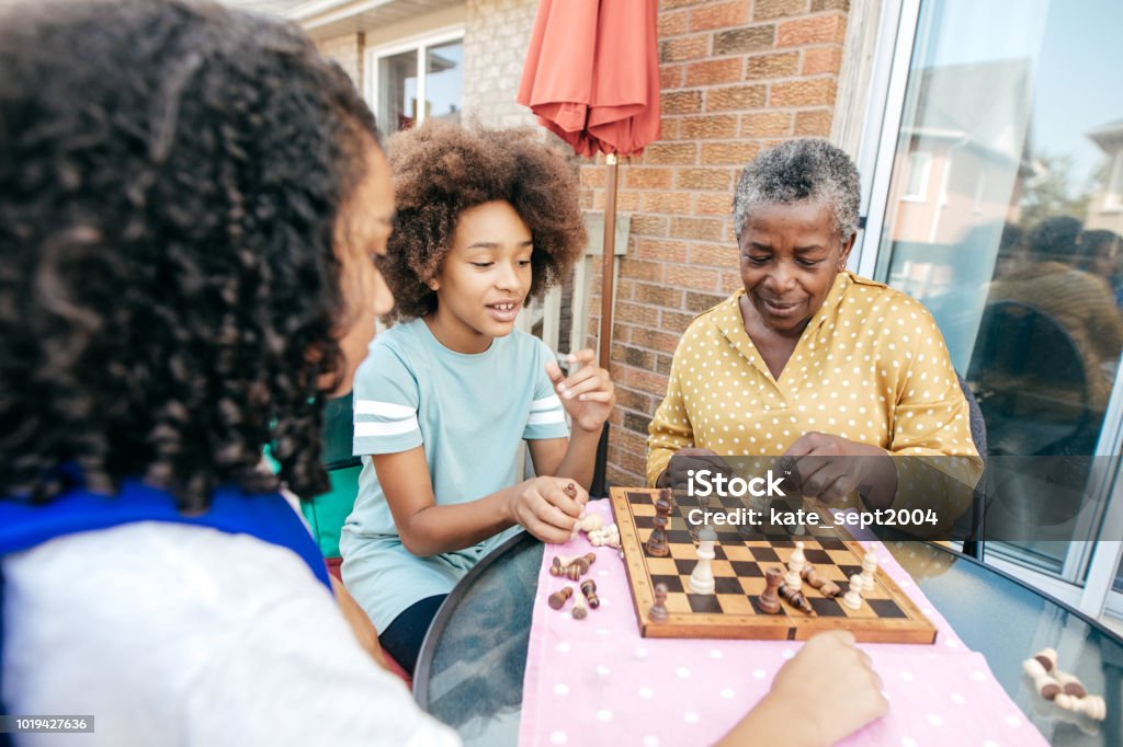 Best grandmother and siblings An old woman and her grandkids playing. Playing Stock Photo