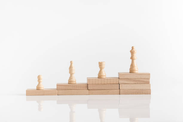 istock White chess pieces on a stepped stack of wooden blocks with queen piece 1019427822