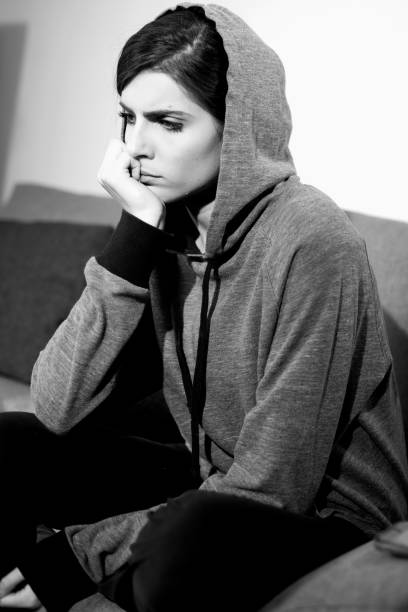 istock Sad young woman with hood thinking black and white 1019438448