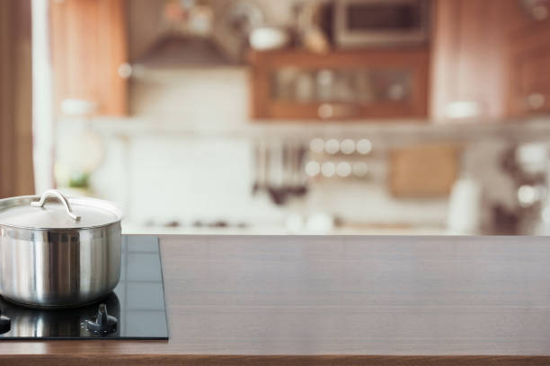 istock Blurred and abstract kitchen background. Wooden tabletop with pan and defocused modern kitchen. 1019445098