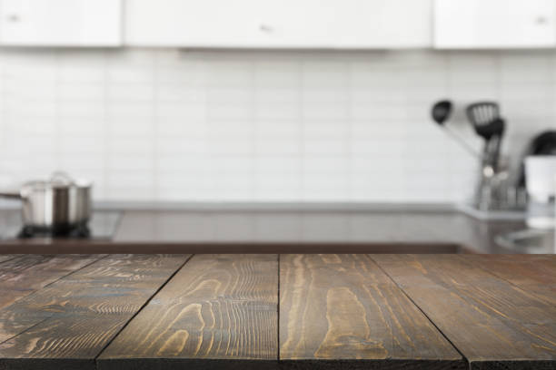 istock Blurred background. Modern defocused pastel kitchen with empty wooden tabletop and space. 1019445600