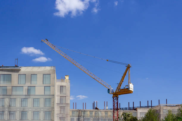 istock Construction crane works against a blue sky background 1019445860