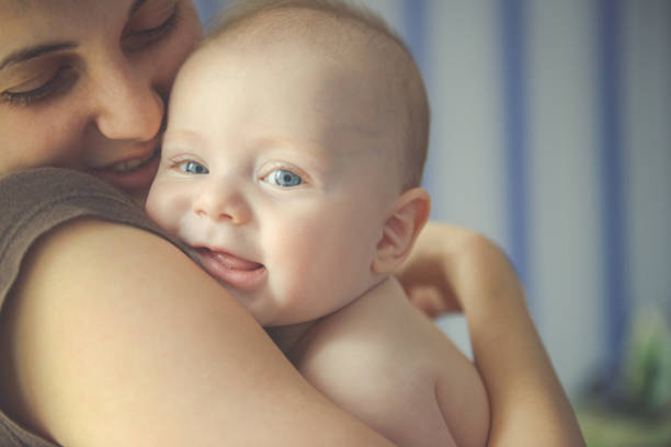 mom hugs a newborn baby and smile - babies and children close up horizontal looking at camera imagens e fotografias de stock