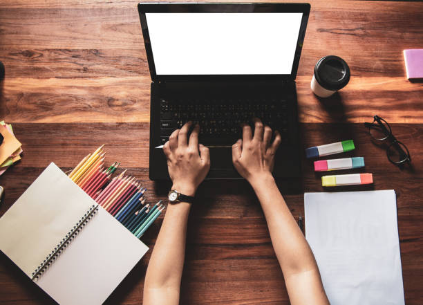 istock Top view.Designer in Scottish shirt, Graphic creative holding Mouse pen and working on laptop in office,Sunset background,Selective focus. 1019455894