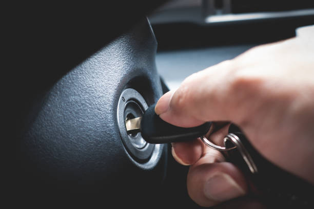 Hand turning car key in the key hole to start the car engine stock photo