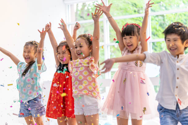 Kids are playing and throwing paper in kid party stock photo