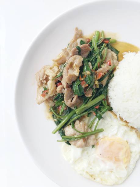 revuelva frito espinacas de agua con harina, huevo frito, estilo tailandés con arroz en plato blanco sobre fondo blanco. comida de estilo tailandés. - jangling fotografías e imágenes de stock