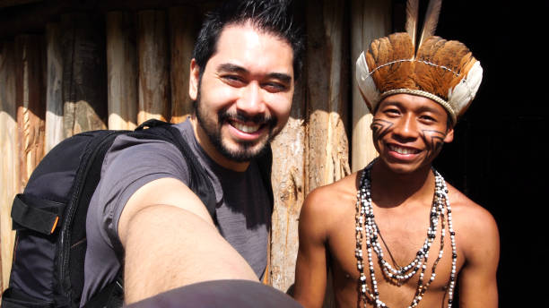 japonesa turista tomando un selfie con hombre indígena brasileña, de la etnia guaraní - viaje al amazonas fotografías e imágenes de stock